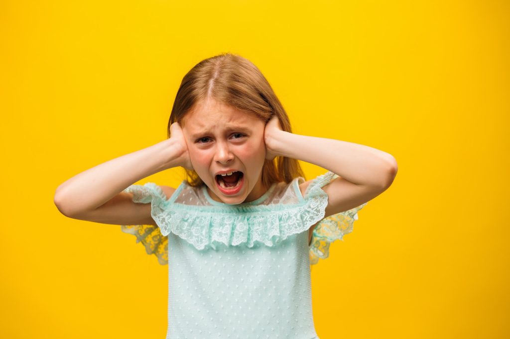 Child anger. portrait of furious little girl kid screaming looking at camera